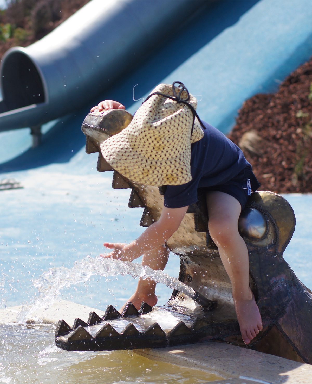 Svg+xml;charset=utf — tract Small child playing with water on a metal crocodile head water feature